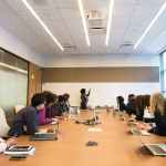 Employees at conference table discussing business ethics and corporate social responsibility